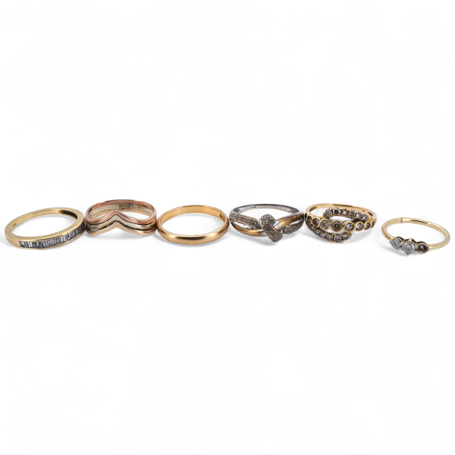 Six rings, comprising: a half eternity ring channel-set with tapered baguette diamonds, mounted in 18ct gold, size P1/2, British hallmarks, gross weight approximately 3 grams; one of half-hoop design, set with brilliant-
